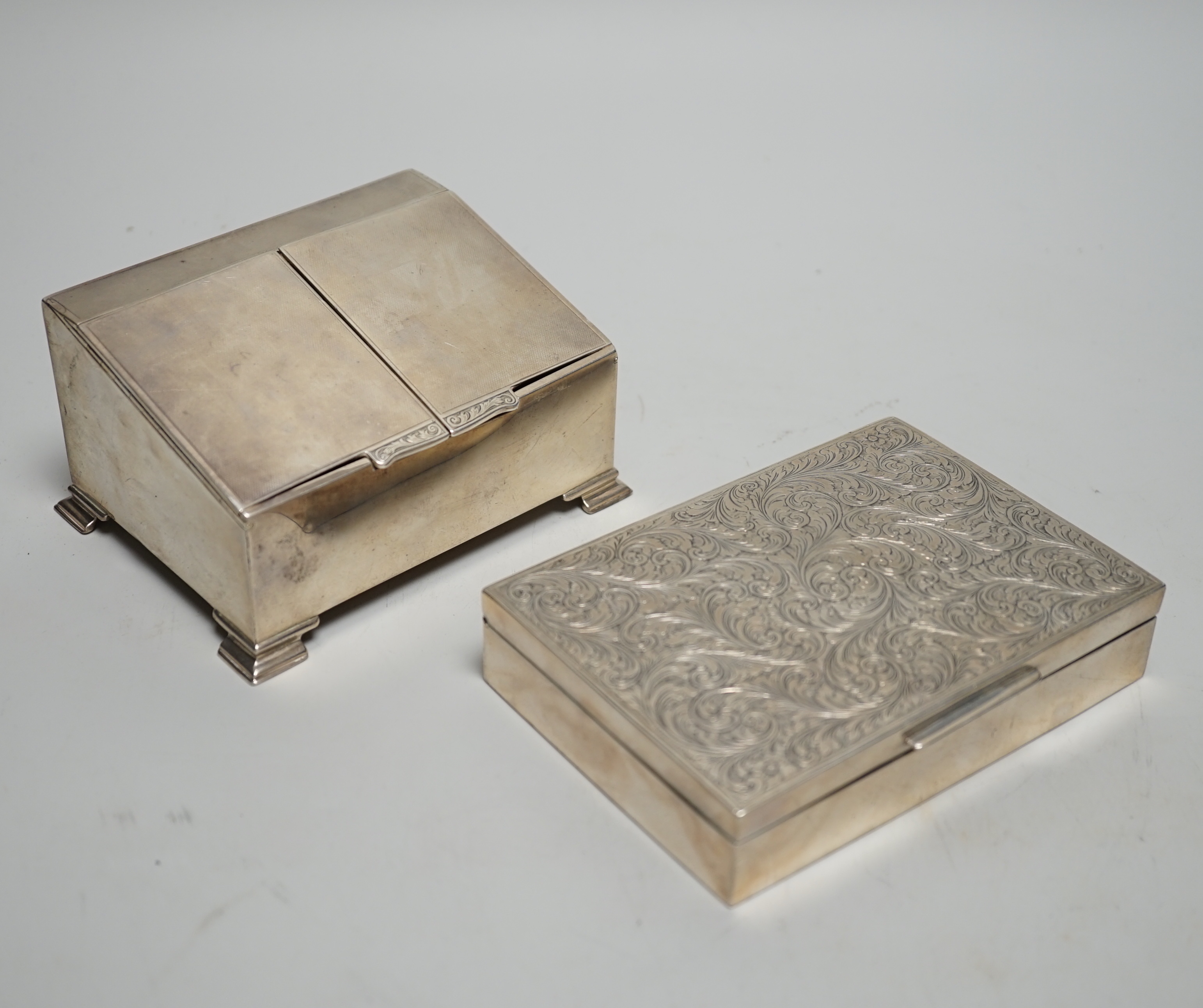 A George V Art Deco engine turned silver twin compartment cigarette box, with slant front, W.I. Broadway & Co, Birmingham, 1929, width 12.3cm, together with an engraved 900 white metal mounted cigarette box.